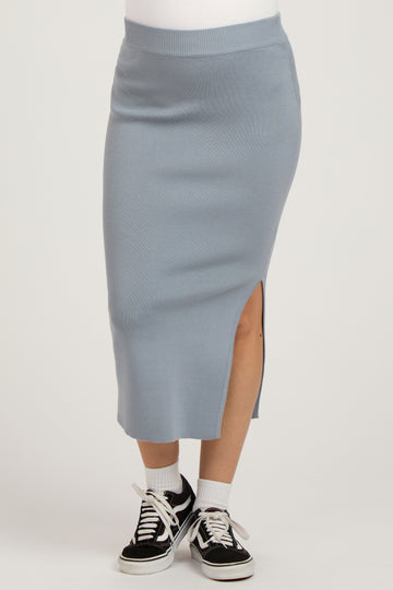 woman wearing a light blue ribbed maternity skirt with a side slit and paired with black sneakers