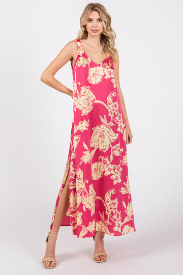 woman wearing a pink floral maxi dress with side slits and a v-neckline