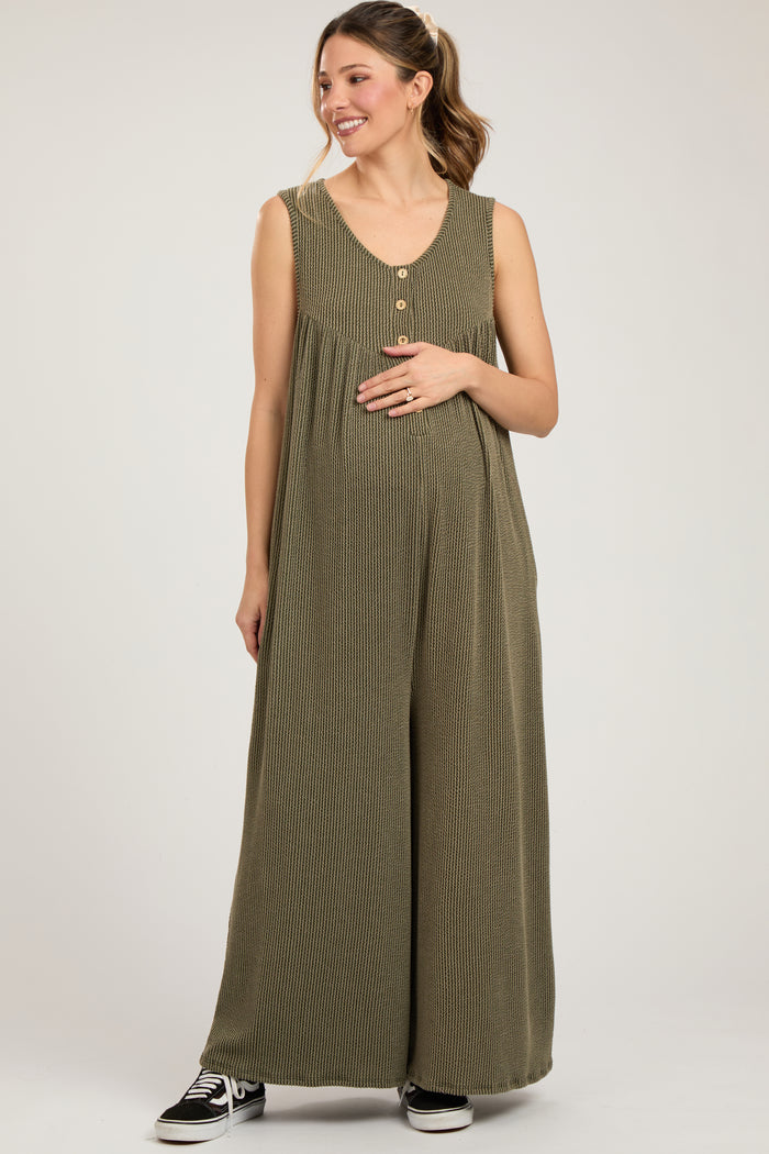 woman wearing a green striped maternity jumpsuit with buttons and a visible baby bump