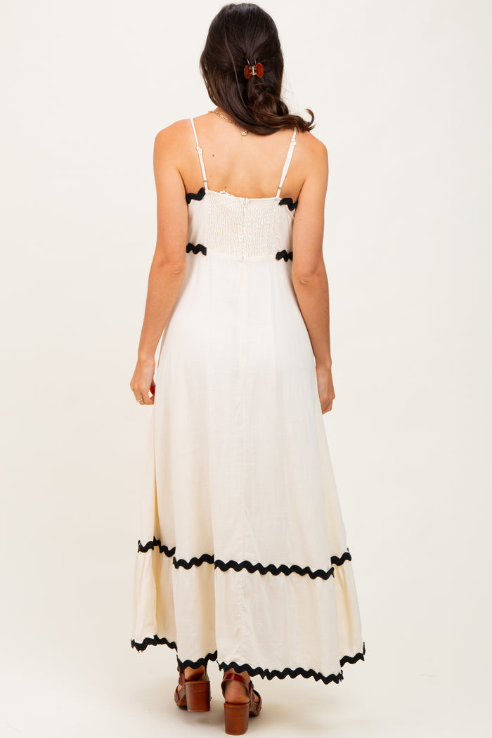 woman wearing a white maxi dress with black trim and spaghetti straps, shown from the back