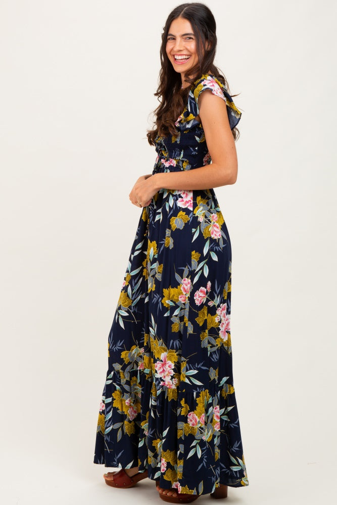 woman wearing a navy floral maxi dress with ruffle sleeves and a tiered hem
