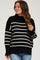 woman wearing a black and white striped maternity sweater with a relaxed fit and crew neckline