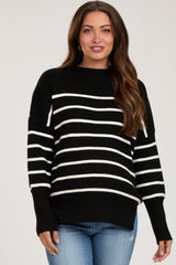 woman wearing a black and white striped maternity sweater with a relaxed fit and long sleeves