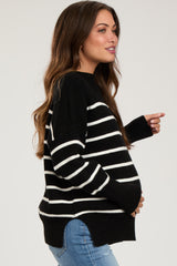 woman wearing a black and white striped maternity sweater and showcasing her baby bump