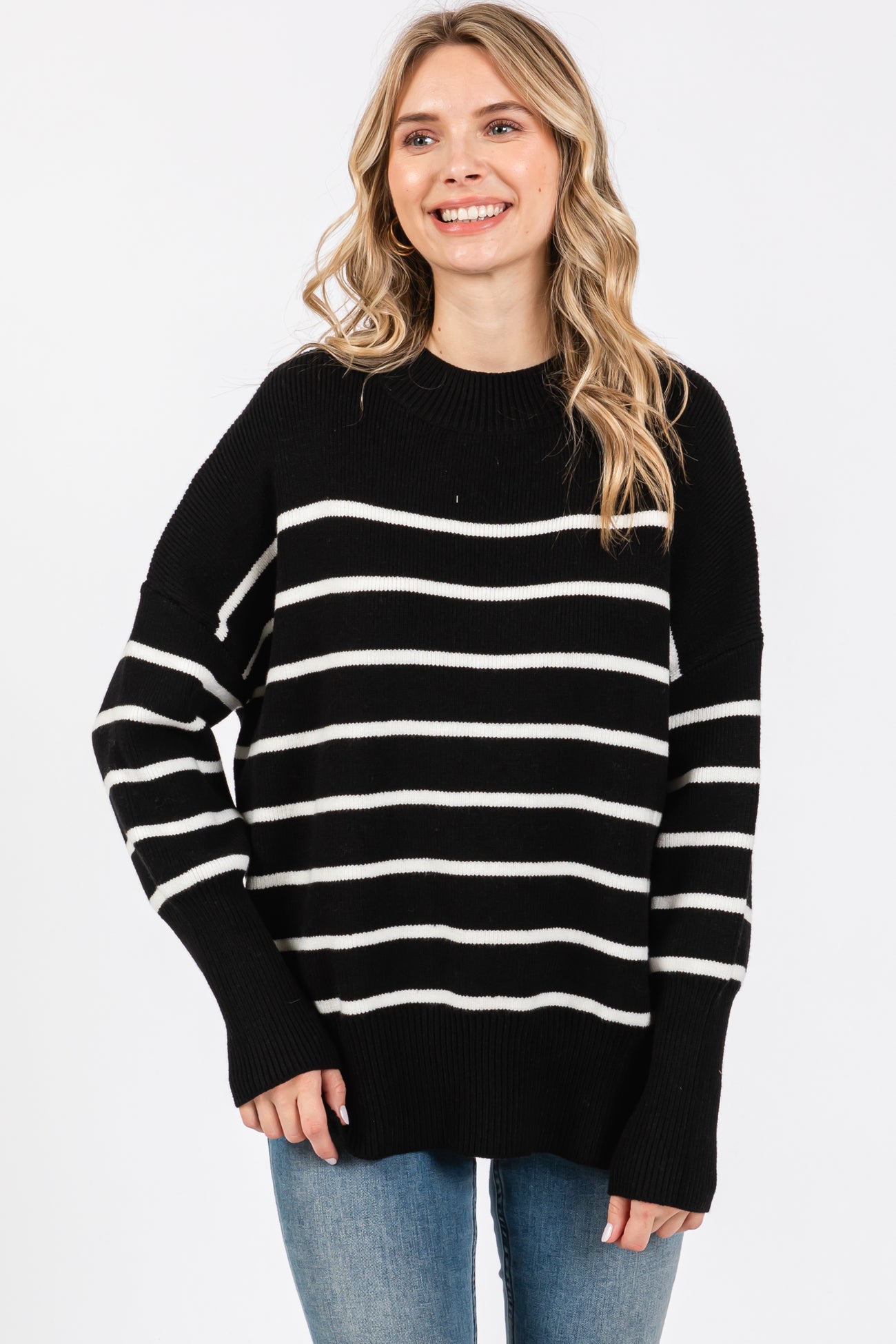 woman wearing a black and white striped oversized sweater with long sleeves and a relaxed fit