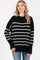 woman wearing a black and white striped oversized sweater with long sleeves and a relaxed fit