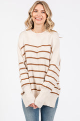woman wearing a cream and brown striped oversized sweater with long sleeves and relaxed fit