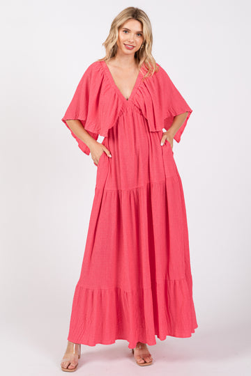 woman wearing a pink tiered maxi dress with short flutter sleeves and pockets