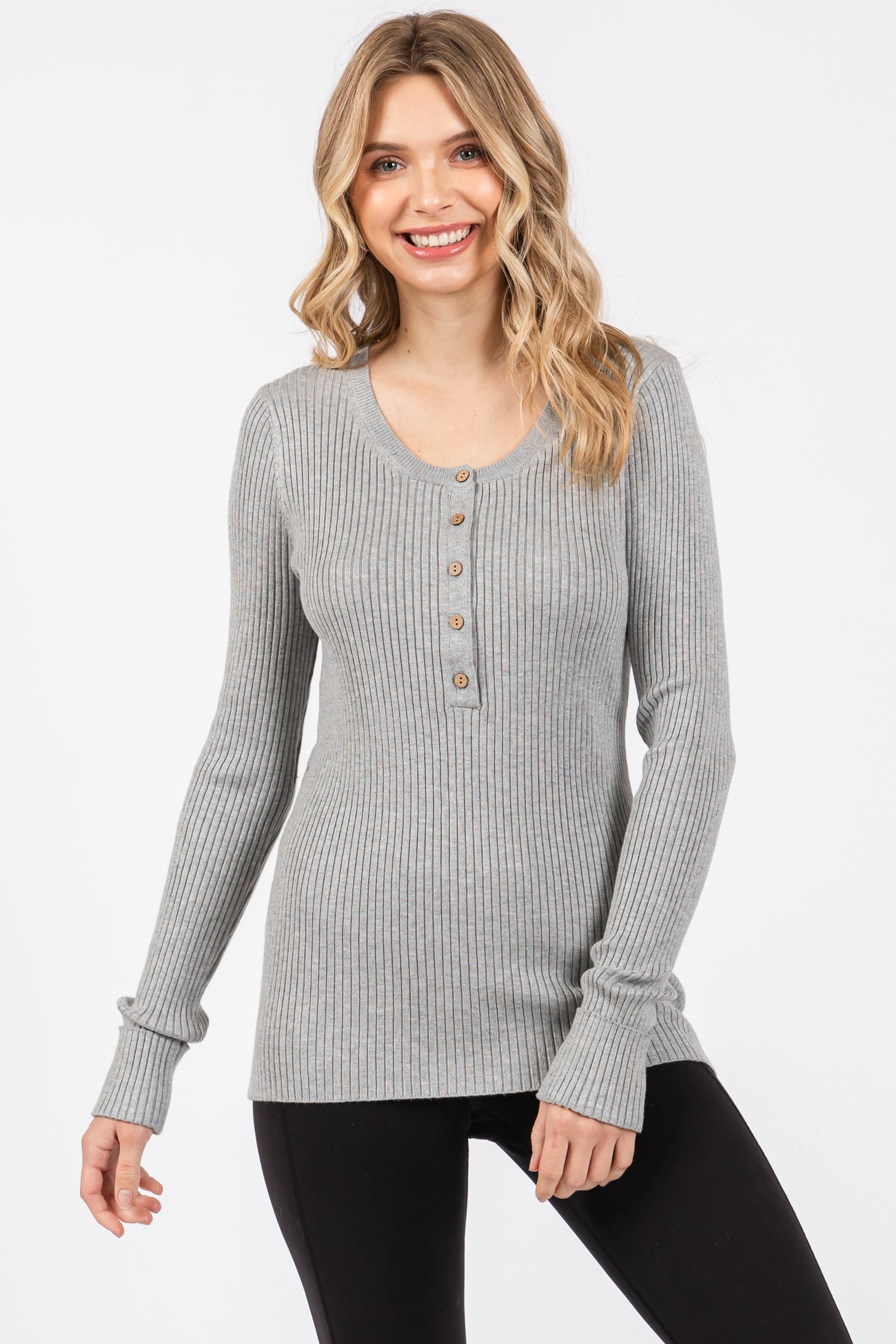 woman wearing a gray ribbed long sleeve henley top with buttons and fitted sleeves