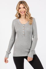 woman wearing a gray ribbed long sleeve henley top with buttons and fitted sleeves