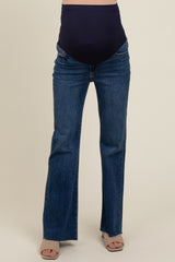 woman wearing dark blue maternity flared jeans with a high waistband, showcasing a baby bump