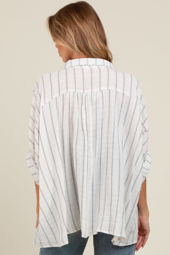 woman wearing a light gray and white striped maternity tunic top, showing the back view and relaxed fit