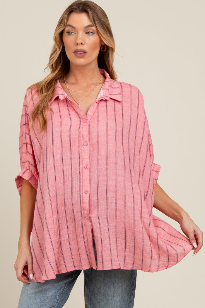 woman wearing a pink striped maternity button-up shirt, styled with rolled sleeves and a relaxed fit, showcasing her baby bump
