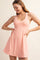 woman wearing a pink athletic tank dress with a fitted bodice and flared skirt
