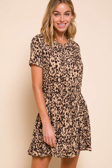 woman wearing a short sleeve leopard print dress with a button front and cinched waist