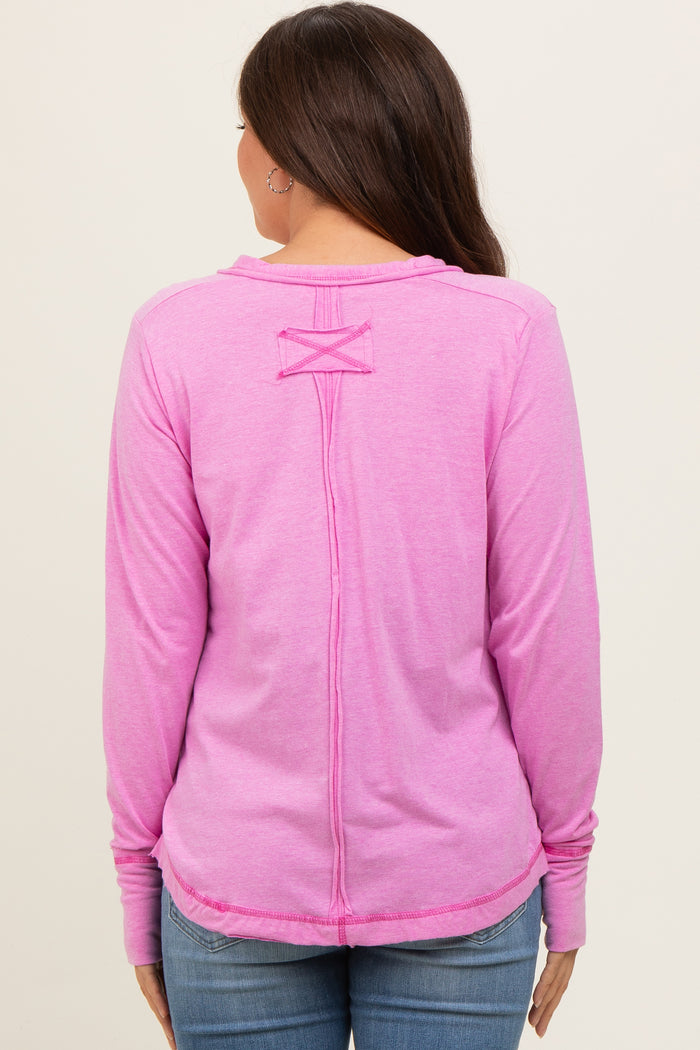 woman wearing a pink long sleeve maternity top with a crisscross back design and casual style