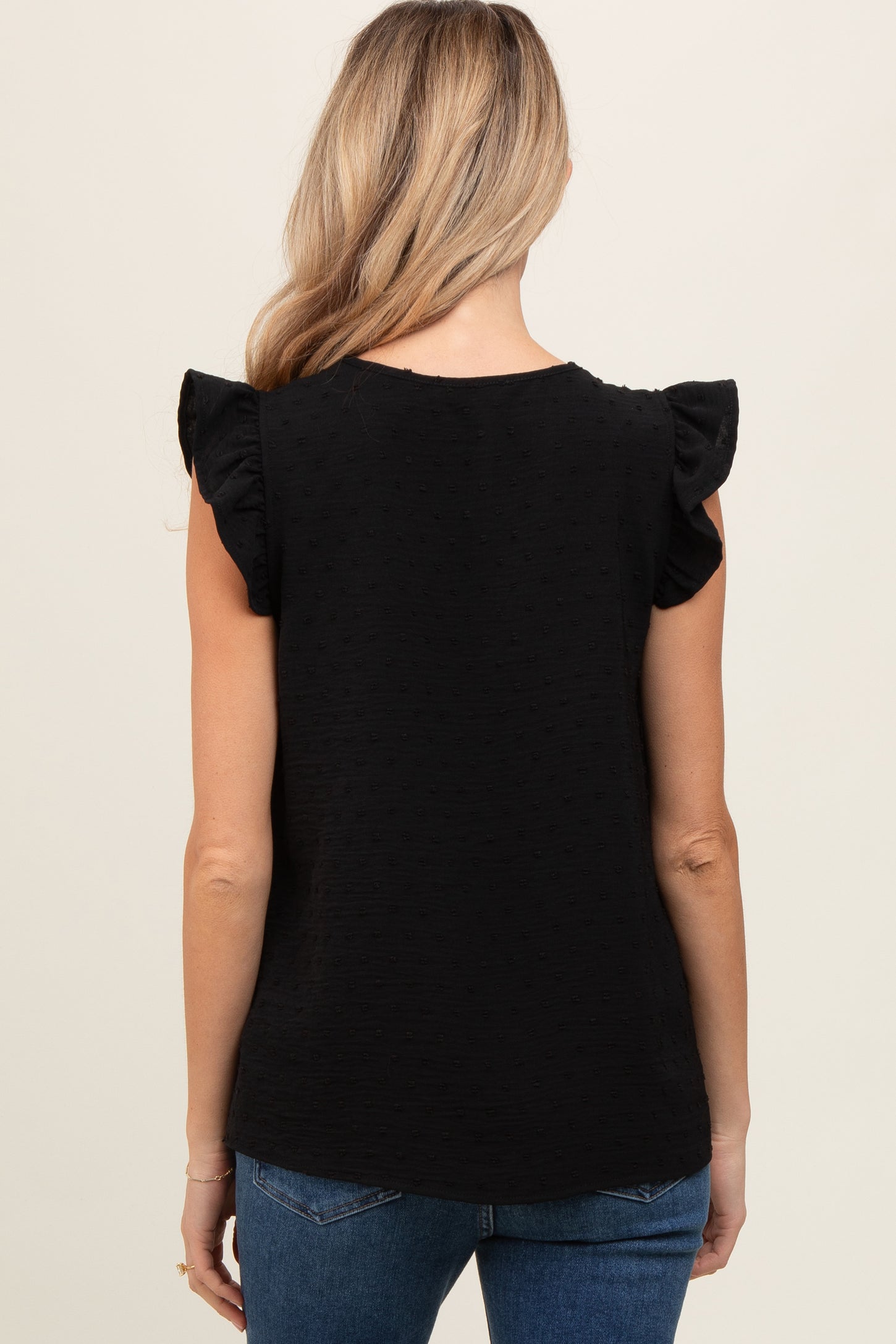 woman wearing a black maternity top with ruffle sleeves, shown from the back
