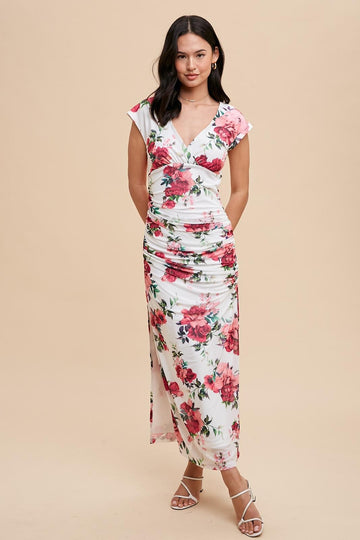 woman wearing a floral print white maxi dress with cap sleeves and ruched detailing