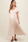 woman wearing a blush pink short sleeve maternity dress with a flowy skirt and a visible baby bump