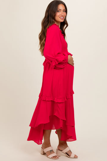 woman wearing a bright pink maternity dress with ruffled layers and a baby bump visible