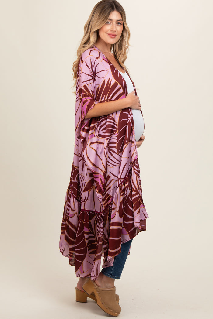 woman wearing a floral print maternity kimono over a casual outfit and showing her baby bump
