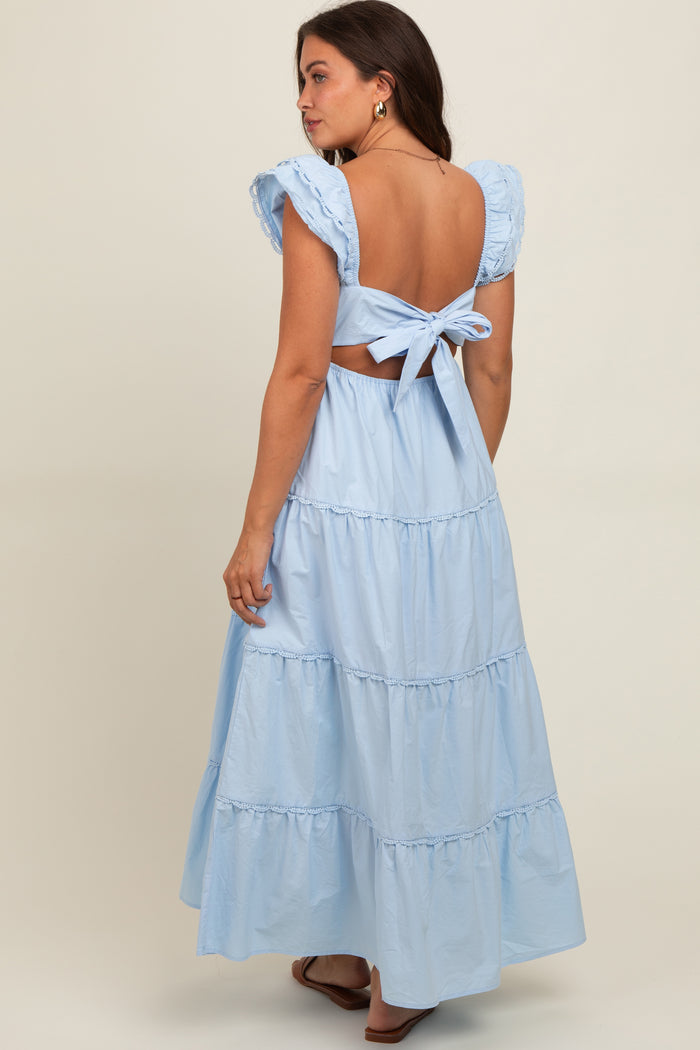 woman wearing a light blue backless maternity dress with ruffle sleeves and a tied waist detail