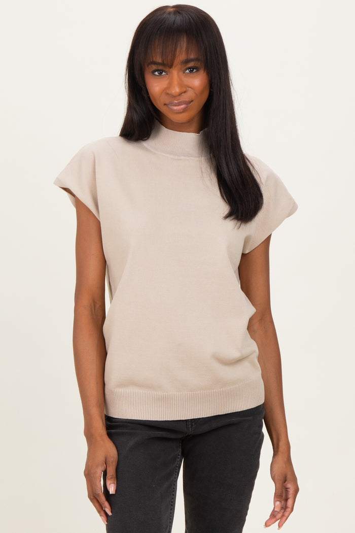 woman wearing a beige short sleeve ribbed mock neck top paired with black jeans