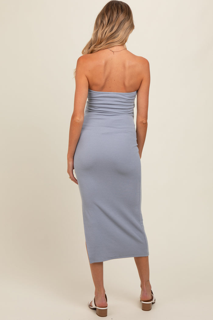 woman wearing a light blue strapless maternity dress with a fitted silhouette and side slits, showing a baby bump