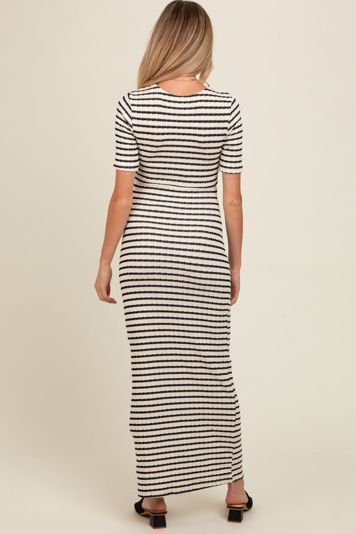 woman wearing a black and white striped maternity maxi dress from the back