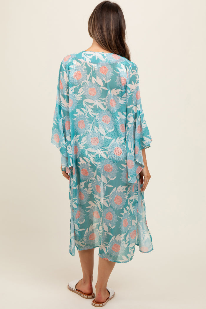 woman wearing a sheer turquoise maternity kimono with floral print, shown from the back