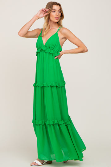 woman wearing a green tiered maxi dress with ruffle details and spaghetti straps