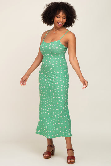 woman wearing a green floral print midi dress with spaghetti straps and brown platform sandals