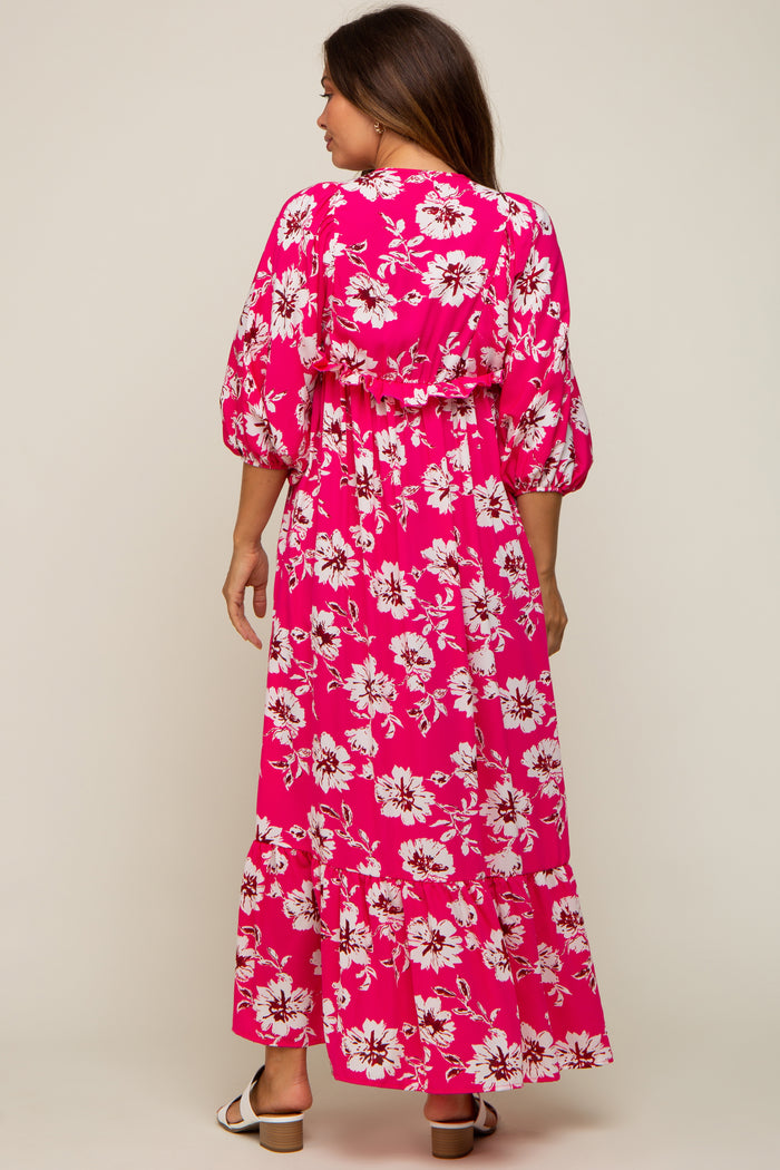 woman wearing a pink floral maternity maxi dress with puffed sleeves and a fitted waist, showing her baby bump from the back